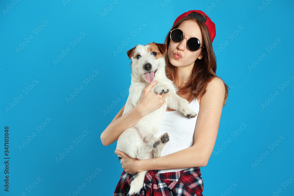 Young woman with her cute Jack Russell Terrier on light blue background. Lovely pet Young woman with her cute Jack Russell Terrier on light blue background. Lovely pet