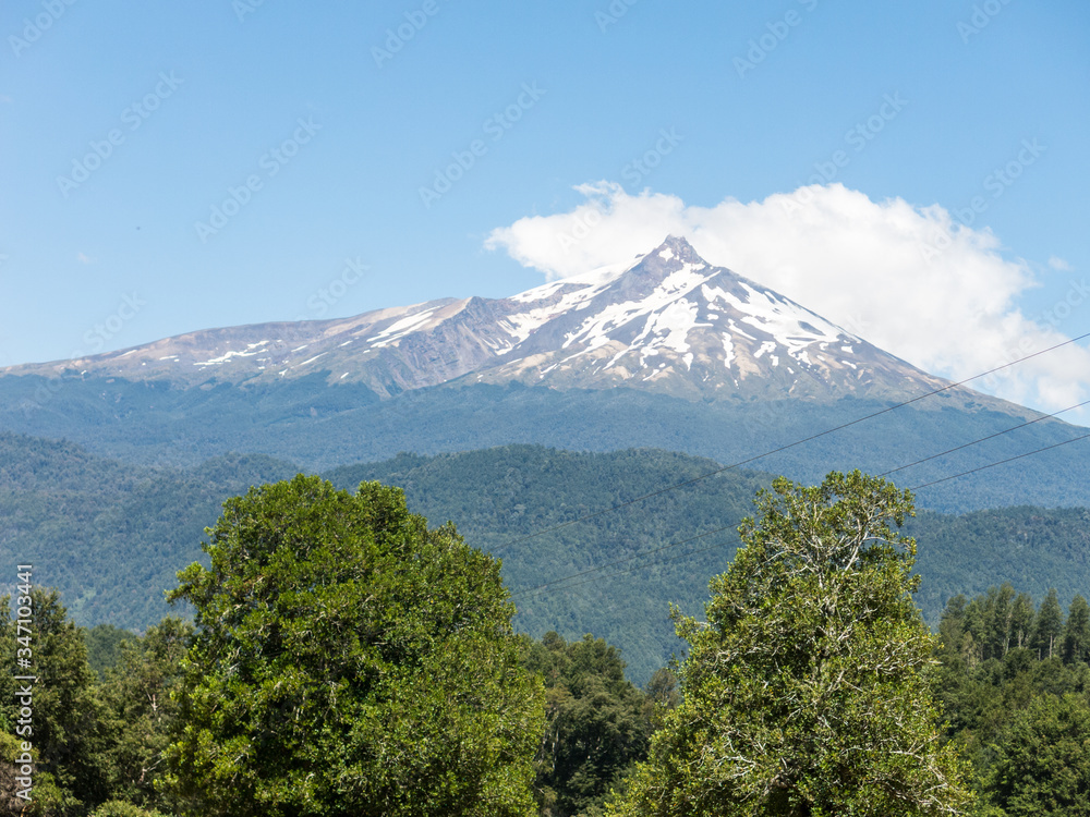 The amazing Choshuenco Volcano surrounded by clouds, over the waters of Lake Panguipulli, in southern Chile. The amazing Choshuenco Volcano surrounded by clouds, over the waters of Lake Panguipulli, in southern Chile.