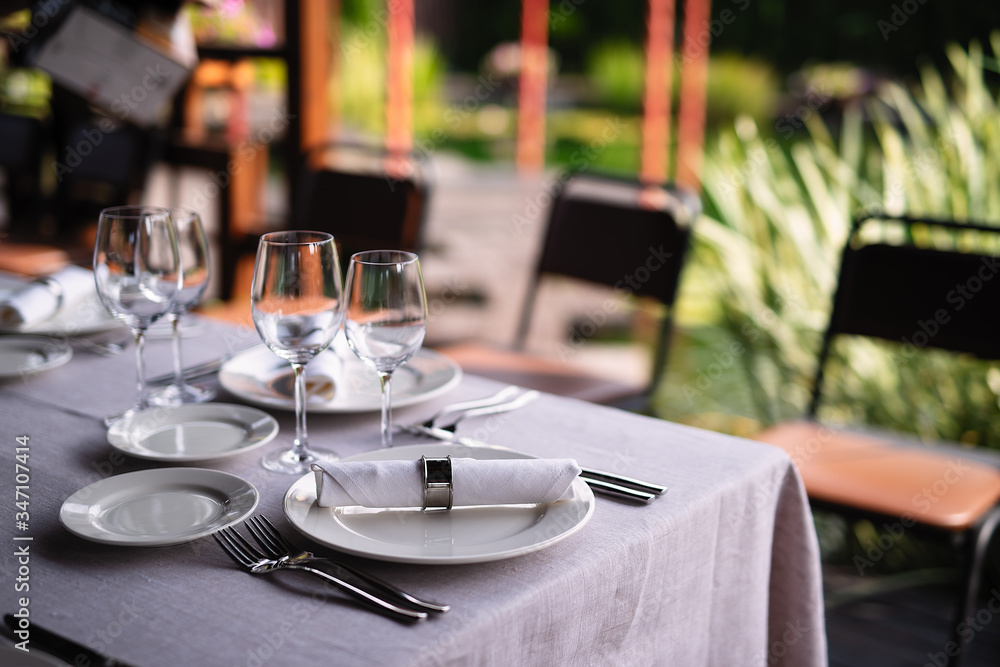 a table with a white tablecloth, white dishes are on the table