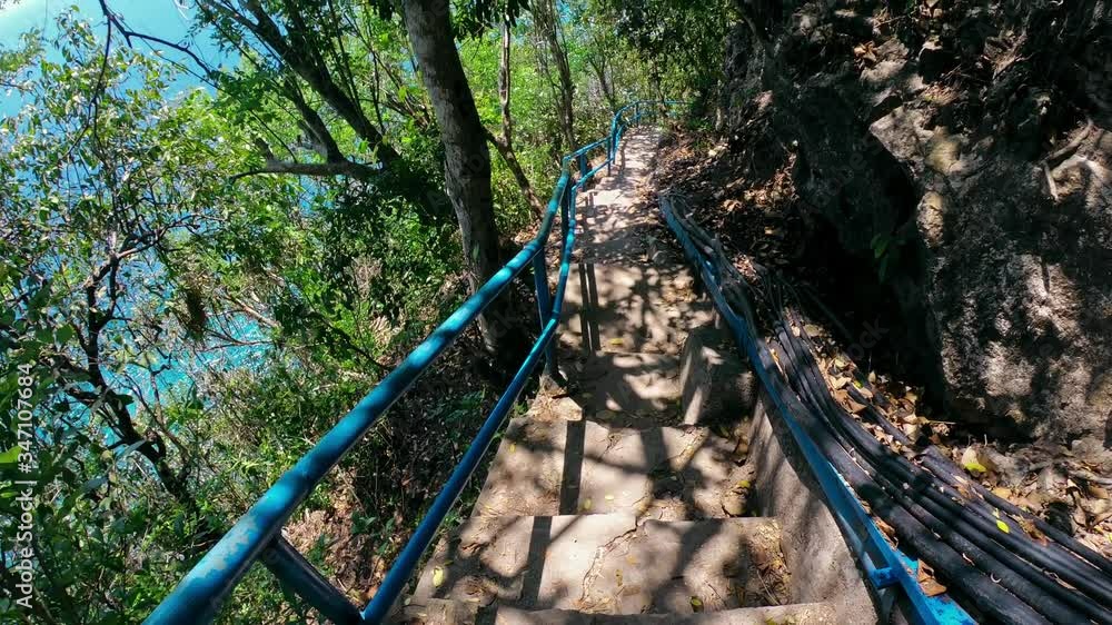 First-person video of a suitable person on an old rock stairs to a cliff on a high mountain