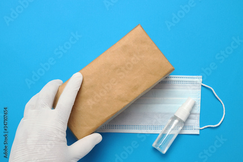 Brown closed carton delivery packaging box ,Hand sanitizer spray and surgical facial mask as protection against influenza photo