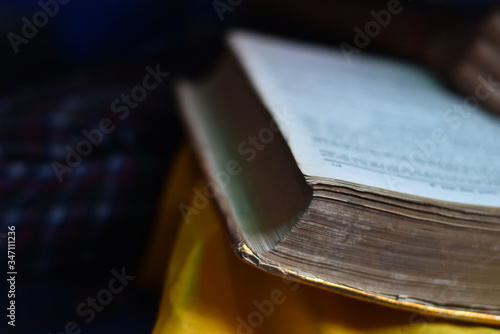 closeup of a Indian girl reading a holy ramayan and bhagwat geeta at home, with blur background. photo