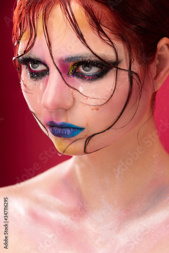 beauty portrait of a girl with bright makeup, fashion close-up portrait, floral makeup, wet skin and drops of water on her face, wet hair and locks of hair photo