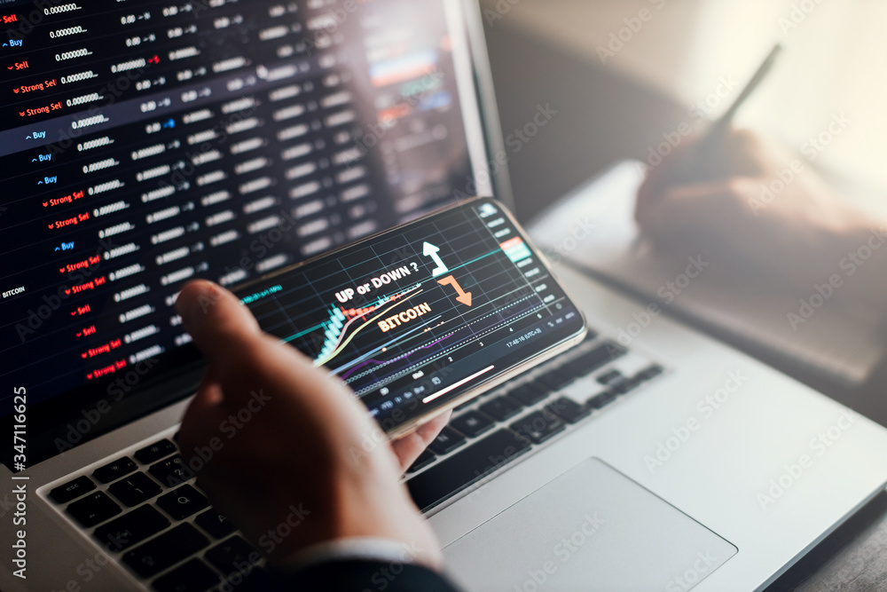 stockbroker using phone and laptop for profit gain analysis workplace stockbroker using phone and laptop for profit gain analysis workplace