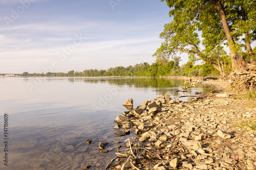 Sunny spring day on Danube river beach with beautiful blue cloudy sky and copy space