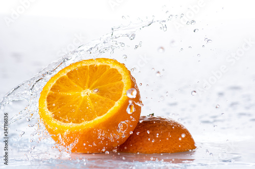 sliced orange with a splash and a stream of water on a white or black background
