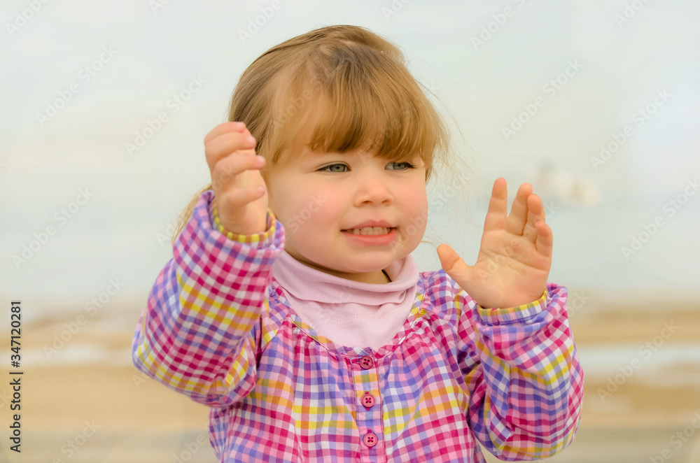 portrait of a pretty little girl playing on the beach portrait of a pretty little girl playing on the beach