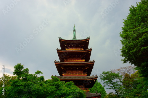 Five Storied Pagoda of Kaneiji Temple at Ueno Park in Tokyo. Gray sky before the rain, green trees