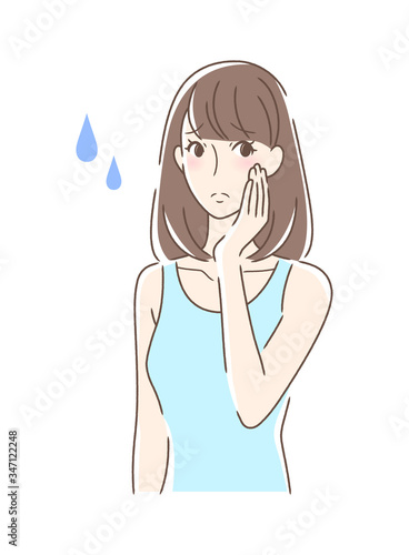 不安そうに頬を触る女性