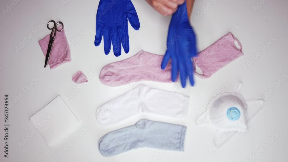 Anonymous person wearing globes near socks to make respirator mask during COVID 19 outbreak Anonymous person wearing globes near socks to make respirator mask during COVID 19 outbreak
