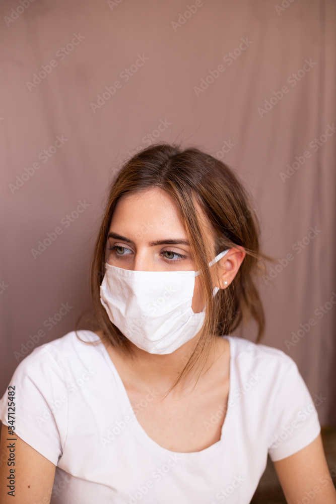 portrait of beautiful young woman wearing cotton white mask and medical/surgical gloves on pastel background. portrait of beautiful young woman wearing cotton white mask and medical/surgical gloves on pastel background.