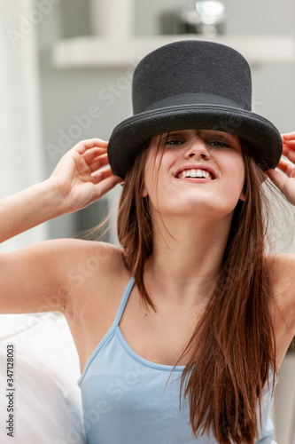 Playful young woman wearing a top hat