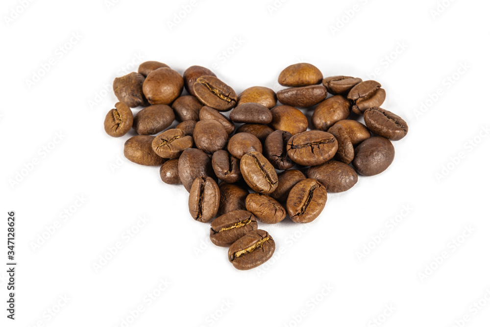 Heart shaped roasted coffee beans on a white background. Heart shaped roasted coffee beans on a white background.