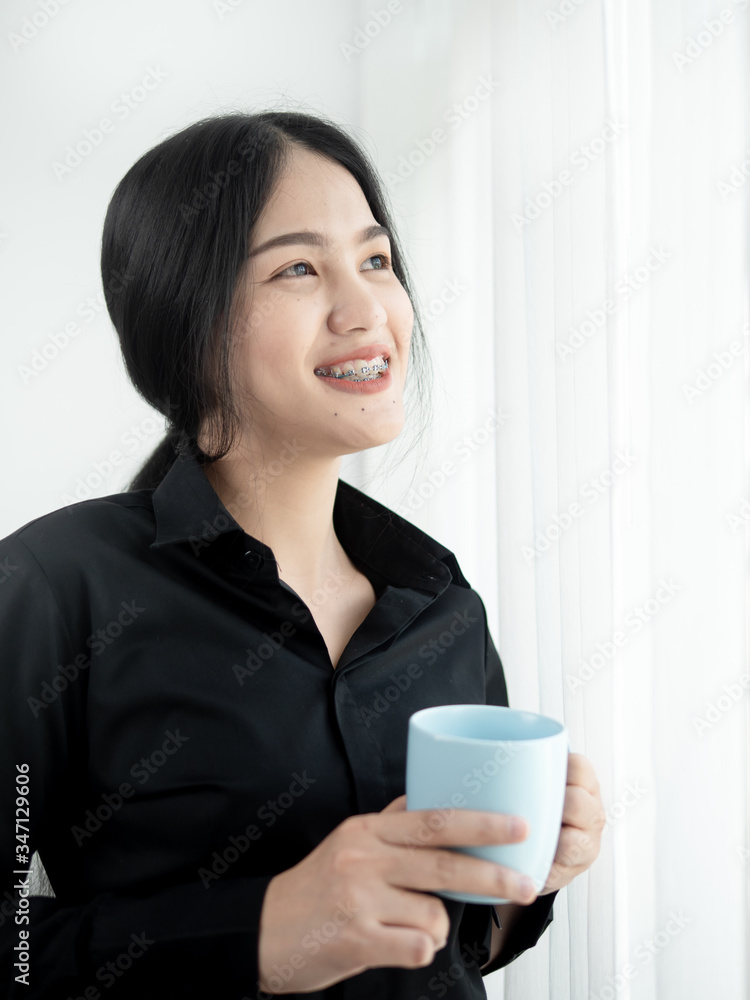 Asian business woman drinking coffee near window in the morning, lifestyle concept. Asian business woman drinking coffee near window in the morning, lifestyle concept.