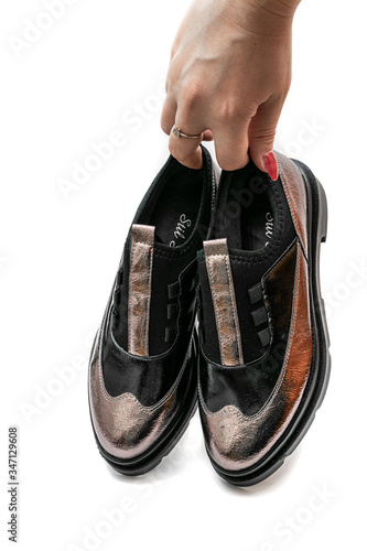 person hand holding a pair of shoes