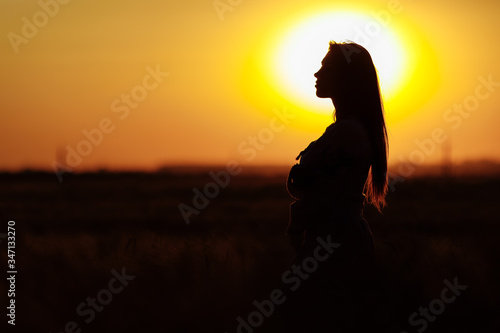 girl at sunset in a wheat field sky