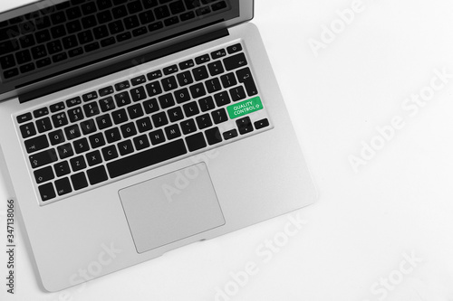 Modern laptop with quality control button isolated on white, top view