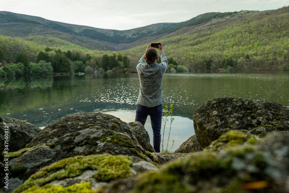 Fototapeta premium a man alone at a lake take a pic