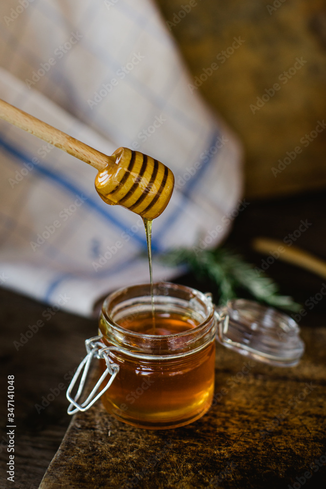 Honey in a glass jar, with a honey scoop. Honey in a glass jar, with a honey scoop.