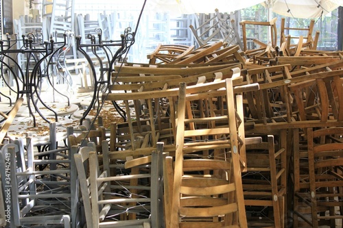 Athens, Greece, May 6 2020 - Tables and chairs stacked outside closed cafe-restaurant during the Coronavirus lockdown.