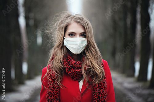Portrait of young woman in protective mask outdoors