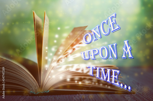 Canvas Print Open book of fairy tales with magic light and text Once upon a time