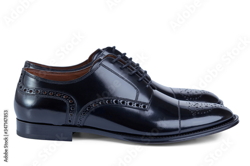 Men's classic shoes derby made of glossy black patent leather on laces with perforated pattern. Side view.