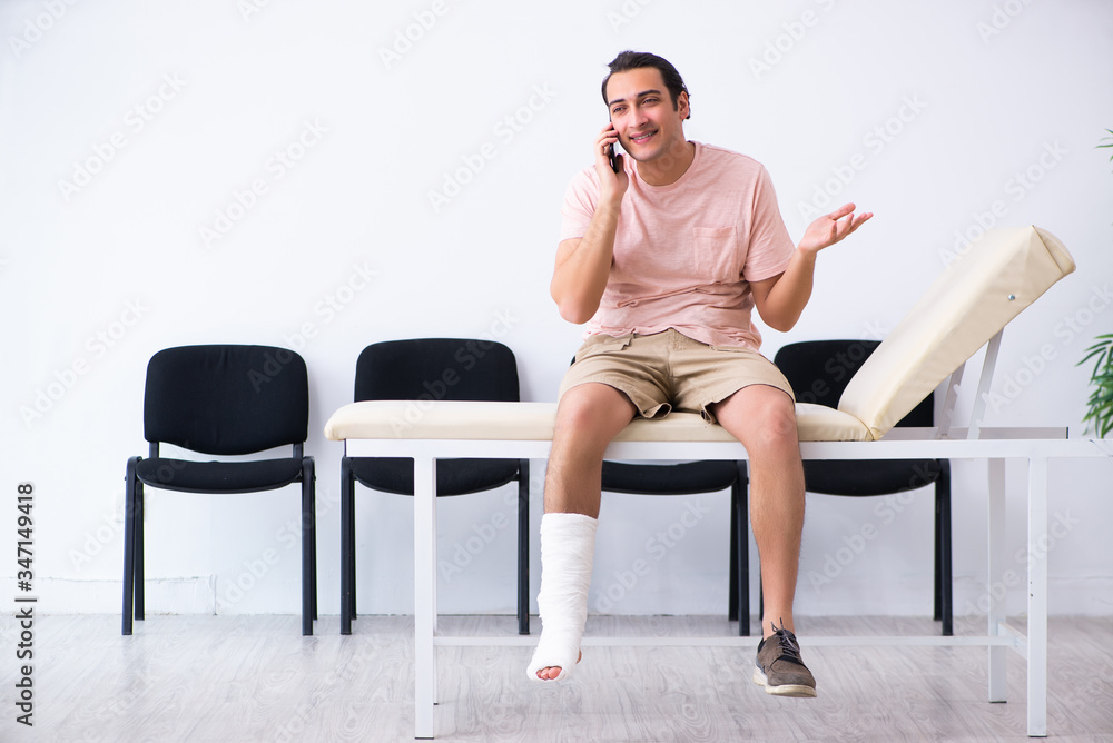 Young injured man waiting for his turn in hospital hall Young injured man waiting for his turn in hospital hall