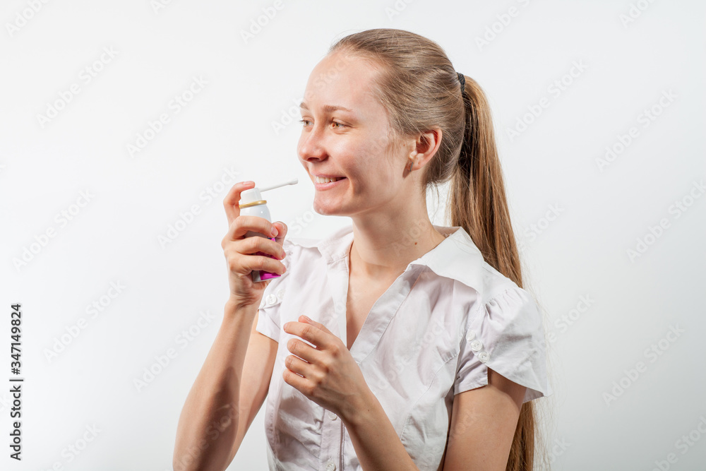 Young and attractive doctor with a throat spray isolated on white Young and attractive doctor with a throat spray isolated on white