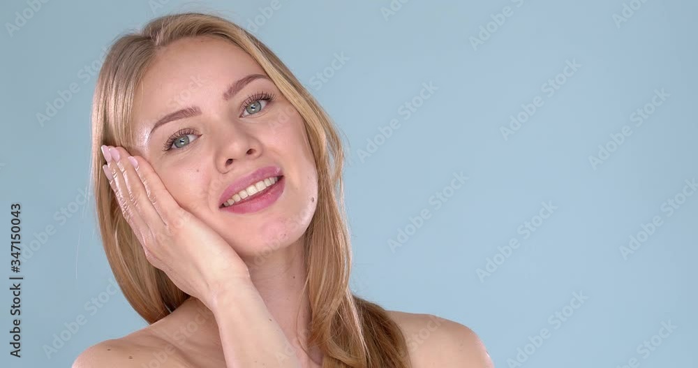 Young beautiful woman bare shoulders portrait. Posing isolated on blue background Young beautiful woman bare shoulders portrait. Posing isolated on blue background