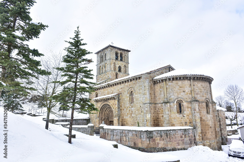 Cervatos, Cantabria, Spain; 1-19-2019; views of the church, its bell tower and trees surrounded by snow
