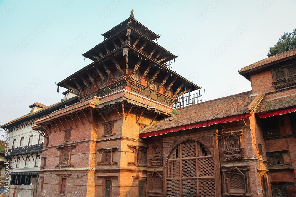 View of ancient hinduism Degutaleju Temple with brick walls and wooden carved statues on Kathmandu Durbar Square at the sunset. Religious architecture theme.