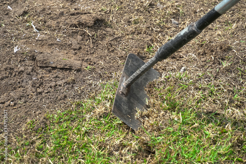 Shovel digging soil in garden