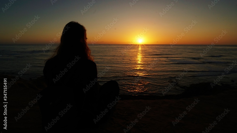 girl watching the sunset at the Sunset Cliffs Natural Park in San Diego.