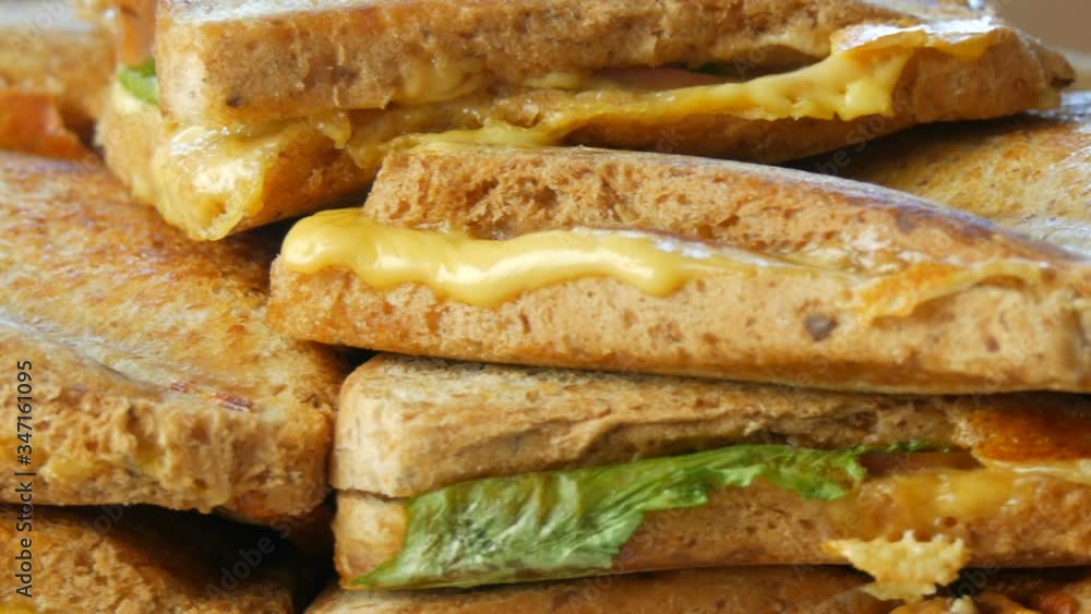 Morning breakfast in the home kitchen. Sandwiches or toasters with bacon, cheddar cheese and lettuce rotate close view Morning breakfast in the home kitchen. Sandwiches or toasters with bacon, cheddar cheese and lettuce rotate close view