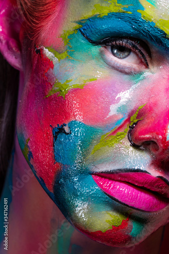 Multicolored skin, difficult to identify. Creative makeup with colorful patterns on the face.