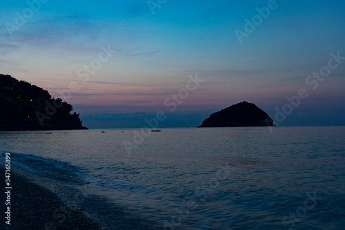 Sunrise over the sea. The sun rises from behind the peninsula and passes from the islet next to it.
Wonderful colors are created, including purple, red, orange, blue.