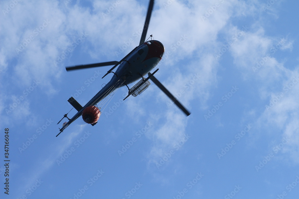 A canadair and a helicopter collect water and fly to the mountains to put out a big fire in Liguria. A canadair and a helicopter collect water and fly to the mountains to put out a big fire in Liguria.