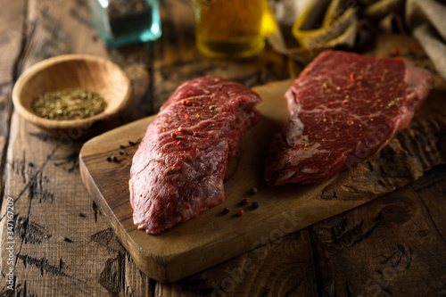 Raw beef steaks on a wooden desk