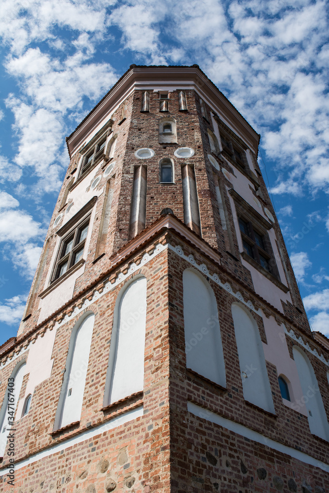 view from below at one of the towers of a Mir castle (belarus) against a blue sky