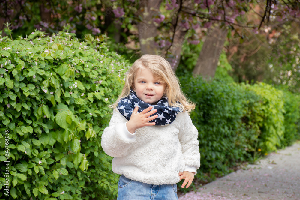 Portrait of a blue-eyed little blond girl on a background of nature in a scarf with stars Portrait of a blue-eyed little blond girl on a background of nature in a scarf with stars