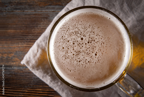 alcoholic beverage , light beer on a dark wooden , top view, close up