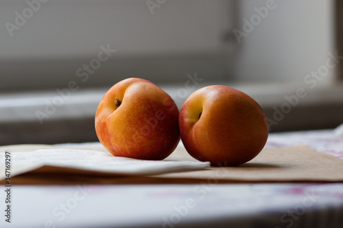 two juicy ruddy peaches lie on the table