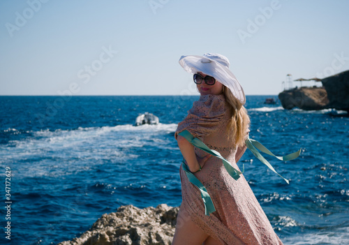 Cute caucasian woman in a white hat resting tourist on the shores of the picturesque Red Sea in Egypt 