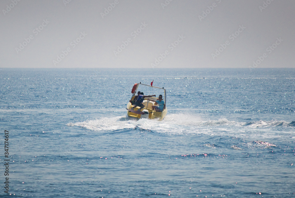 Tourist speed boat rides tourists vacationing on the Mediterranean coast of Turkey