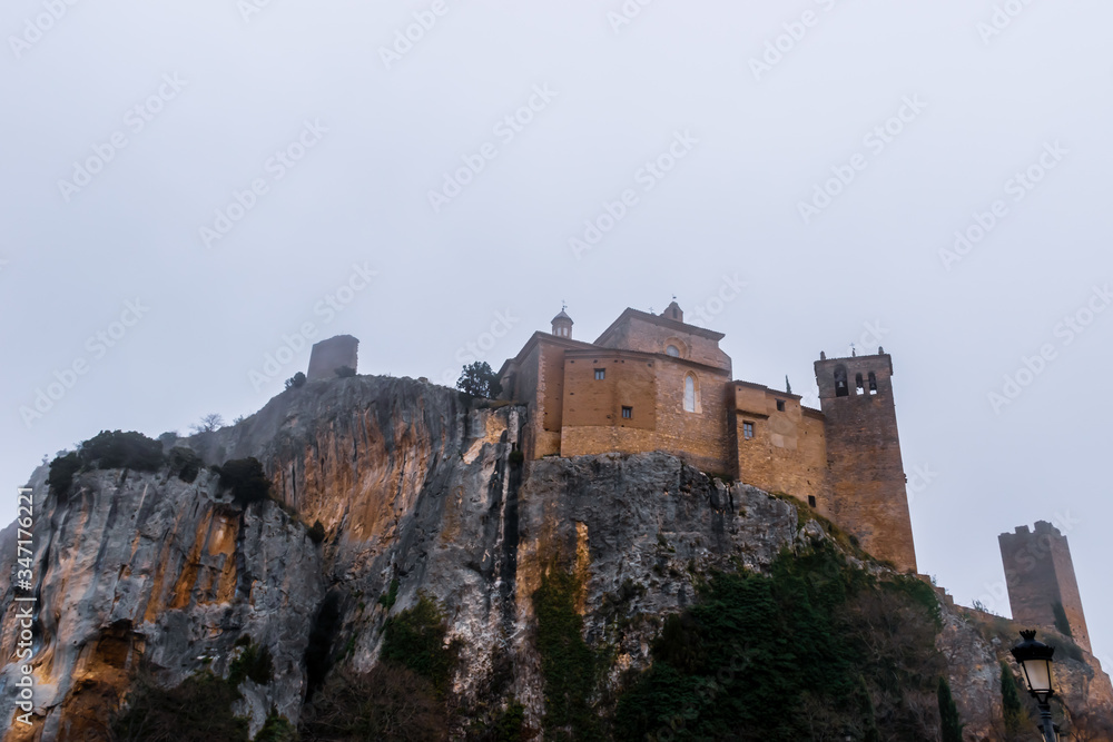 A bottoms-up picturesque view of the medieval castle of Alquézar (Huesca, Spain) on a cliff in the Spanish Pyrenees on a cloudy winter morning