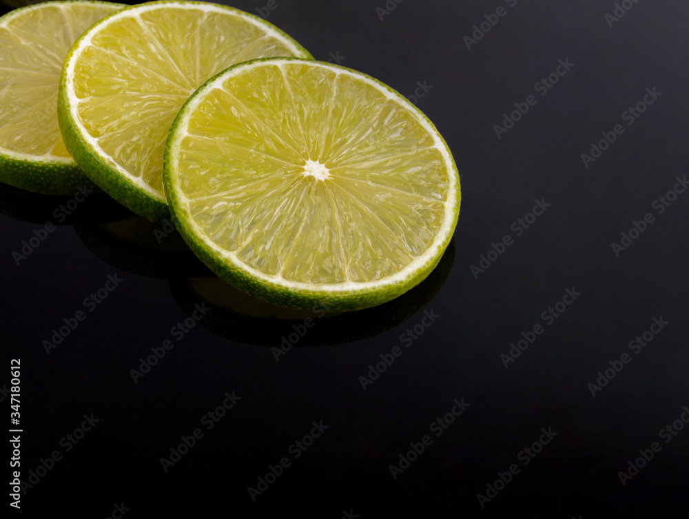 Fresh green lime sliced on black background. Fresh green lime sliced on black background.
