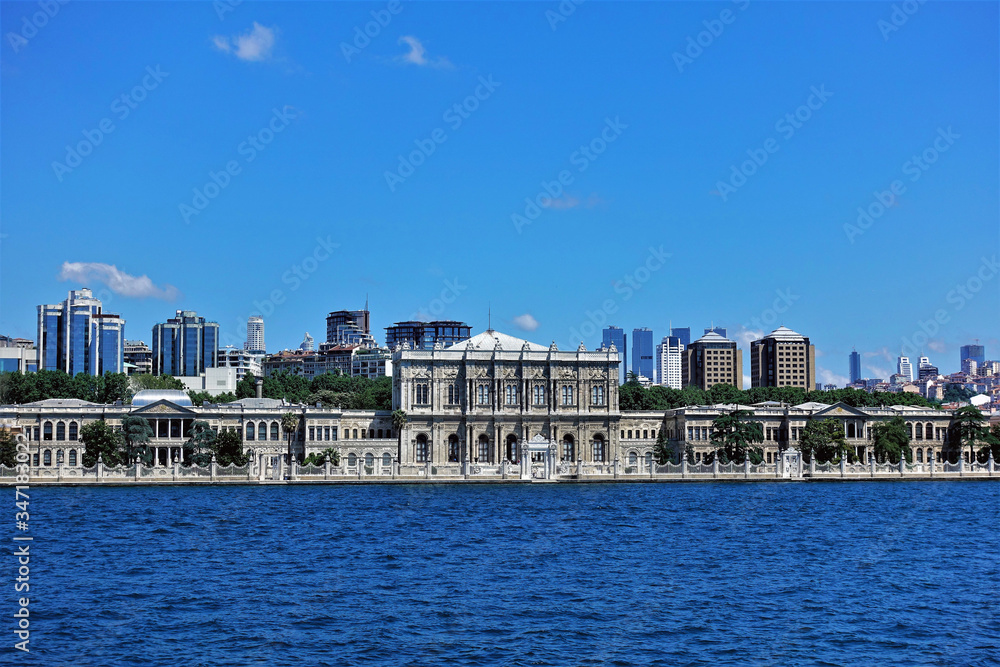Panorama of Istanbul. On the banks of the Bosphorus Strait a luxurious old palace with delicate decorations and gratings. Far away are the modern buildings. Clear blue sky.