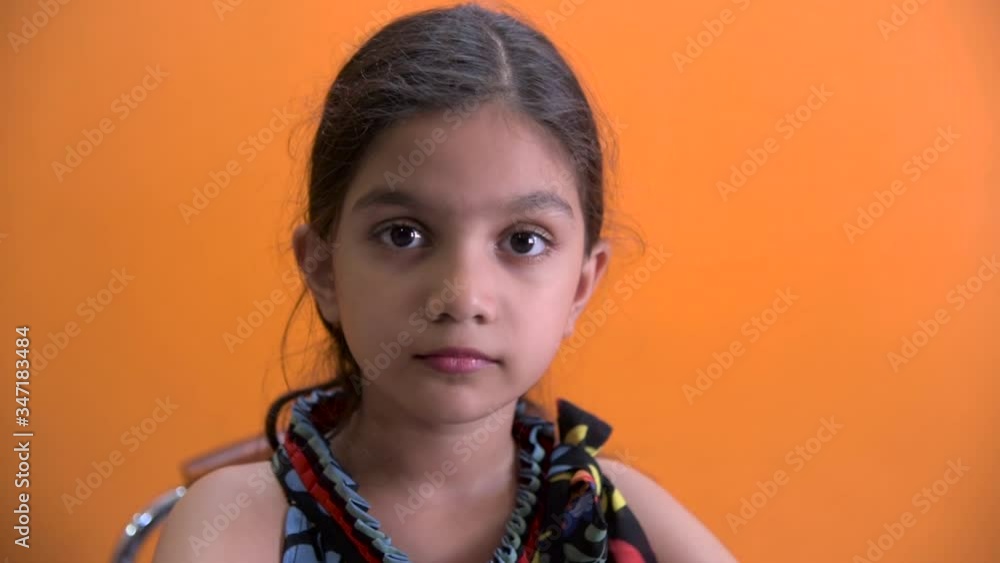 Cute girl staring at camera with beautiful expressions, with little smile and looking here and there Cute girl staring at camera with beautiful expressions, with little smile and looking here and there