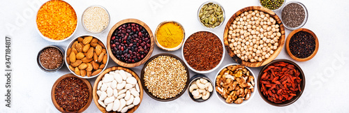 Various superfoods  legumes  cereals  nuts  seeds in bowls on white background. Superfood as chia  spirulina  beans  goji berries  quinoa  turmeric  mung bean  buckwheat  lentils  flax seed